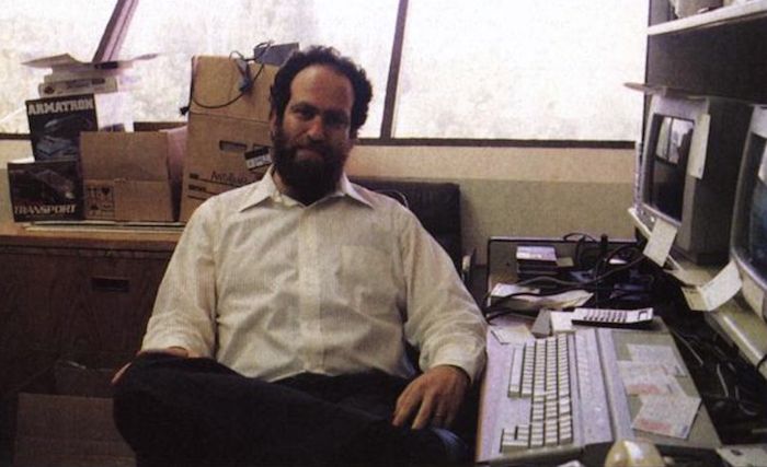 Leonard Tramiel seated in an office beside an Atari ST and monitor
